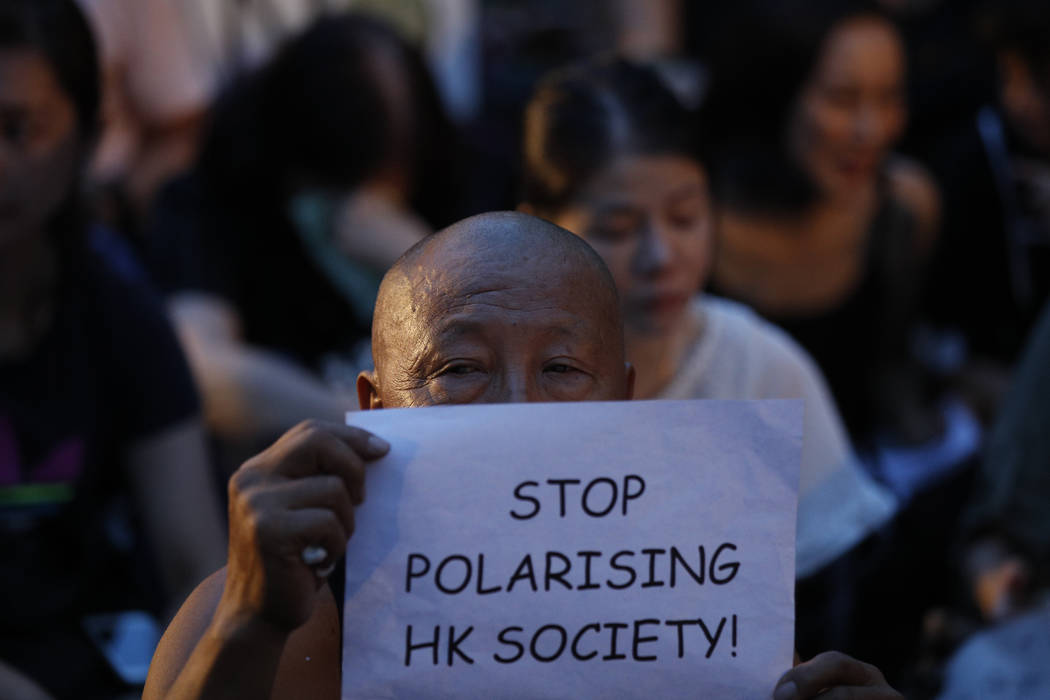 A man holds a card while joining a rally by mothers In Hong Kong on Friday, Jan. 5, 2019. Stude ...