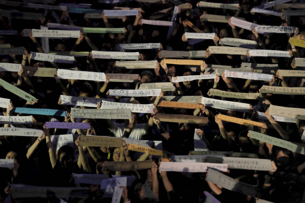 Attendees hold up banners some with words "Waiting for you to come home" and "Ho ...