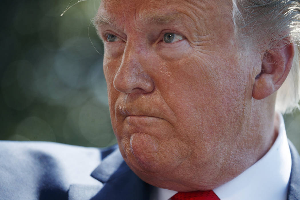 President Donald Trump listens to a question from a reporter on the South Lawn of the White Hou ...