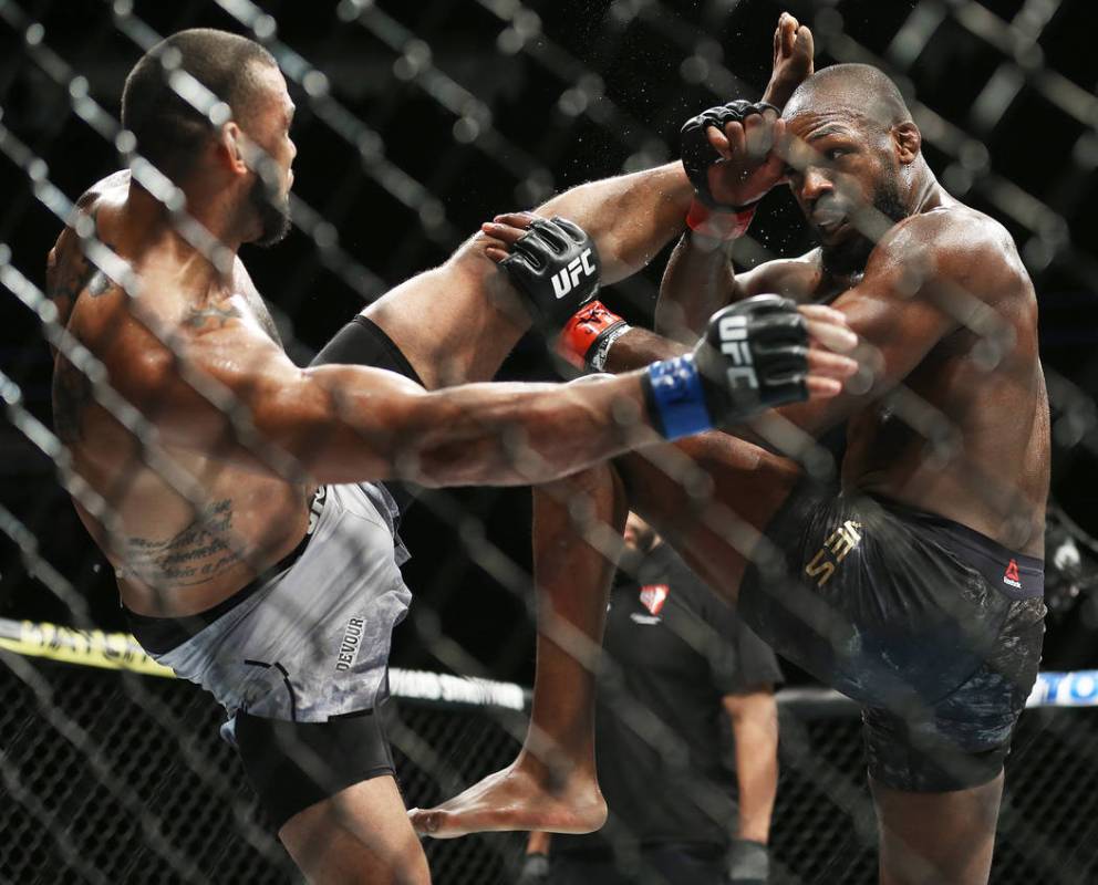 Jon Jones, right, blocks a high kick by Thiago Santos in the fifth round during their light hea ...