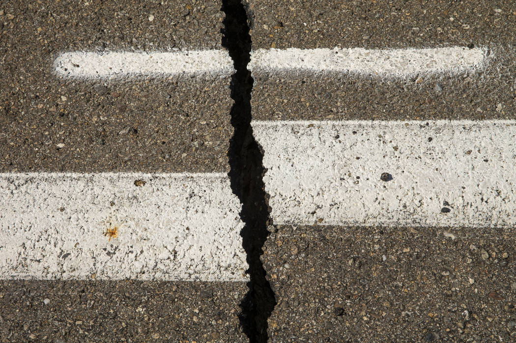 Caltrans workers continue to monitor the extensive cracks with shifting pavement that have open ...