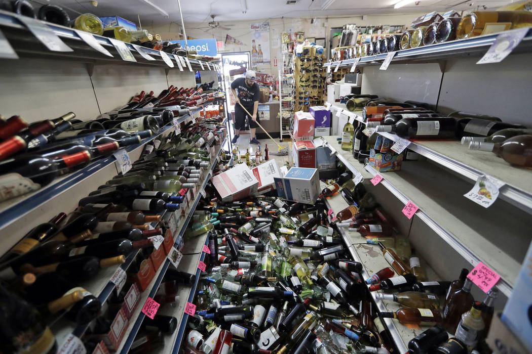 Bottles of wine are strewn in the middle of an aisle as Victor Abdullatif, background center, m ...