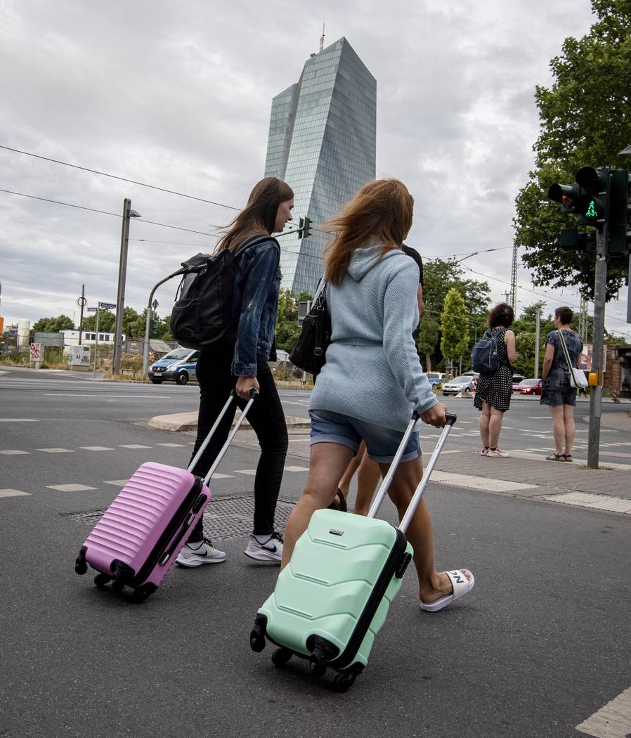 People leave the forbidden area near the European Central Bank, background, with a tram as 16 0 ...