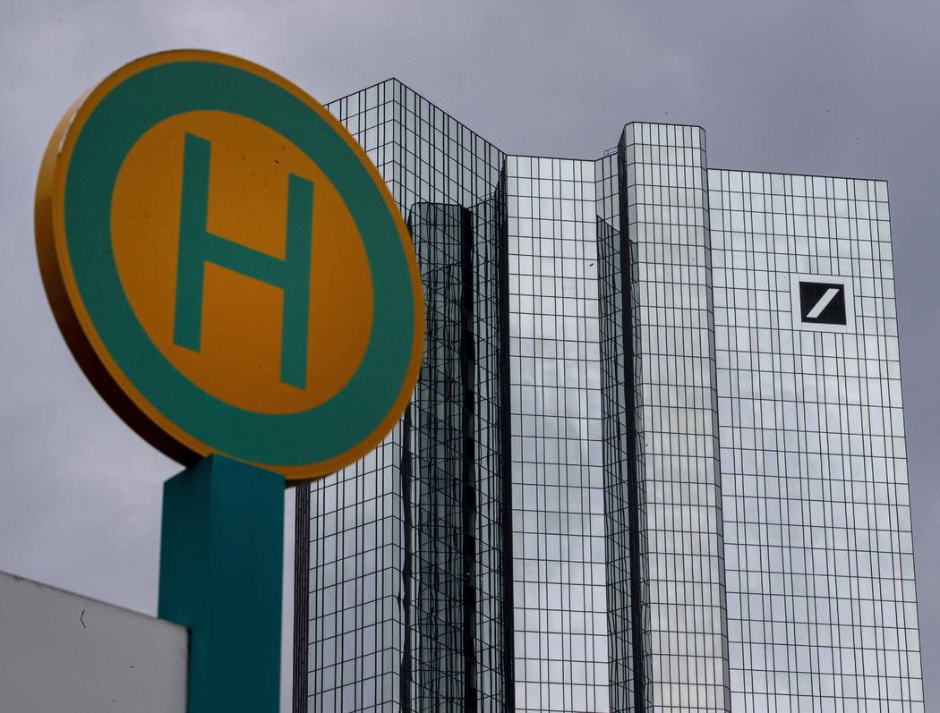 The headquarter of Deutsche Bank is seen next to a bus stop sign in Frankfurt, Germany, Sunday, ...