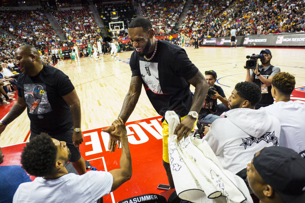 Los Angeles Lakers' LeBron James arrives to sit courtside before the start of a game between th ...