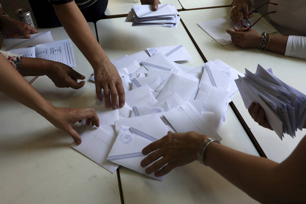 Election representatives count ballots after polling station closed in Athens, on Sunday, July ...