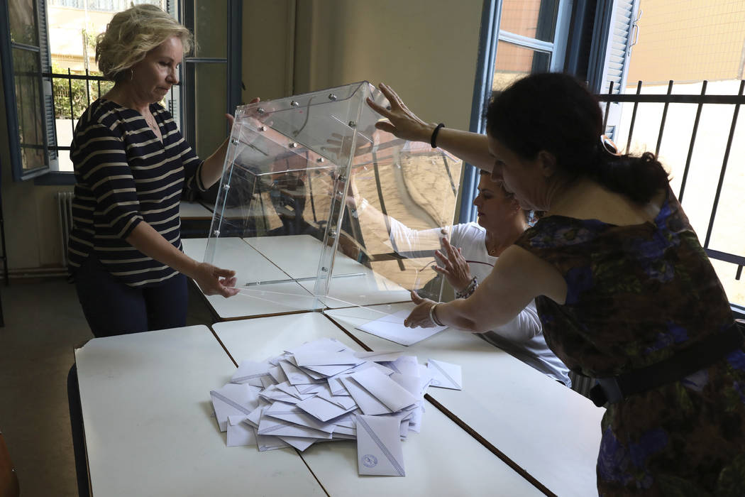 Election representatives count ballots after polling station closed in Athens, on Sunday, July ...