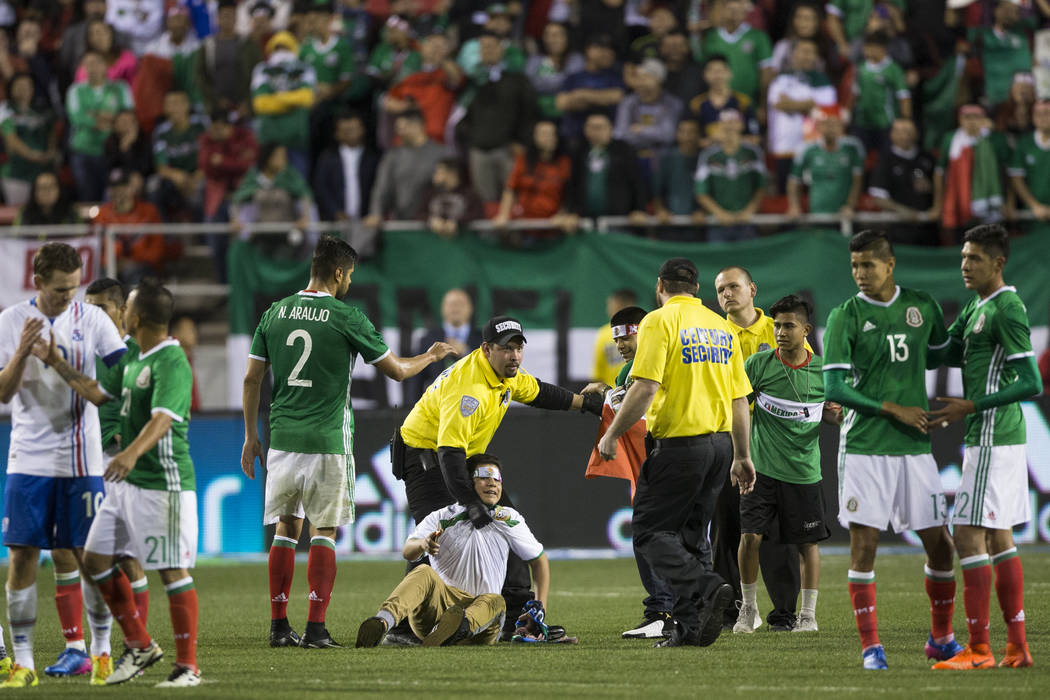 Fans run to the field at the end of the men's soccer exhibition match between Mexico and Icelan ...