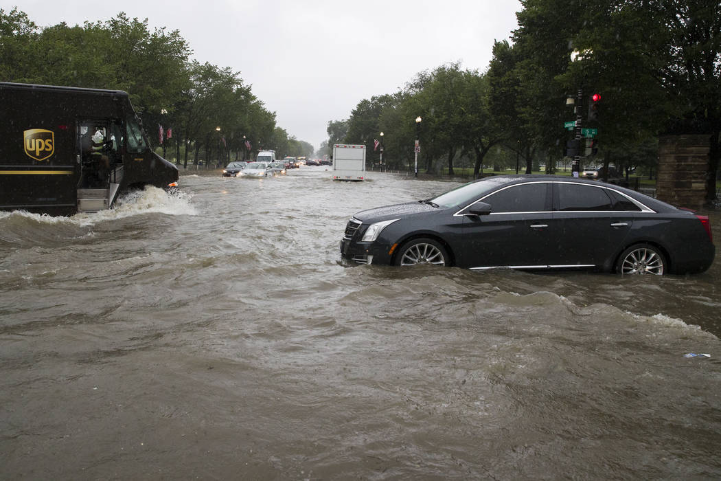 Heavy rainfall flooded the intersection of 15th Street and Constitution Ave., NW stalling cars ...