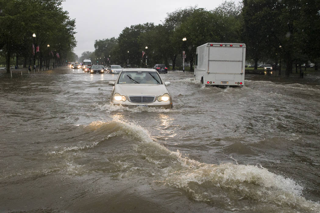 Heavy rainfall flooded the intersection of 15th Street and Constitution Ave., NW, stalling cars ...