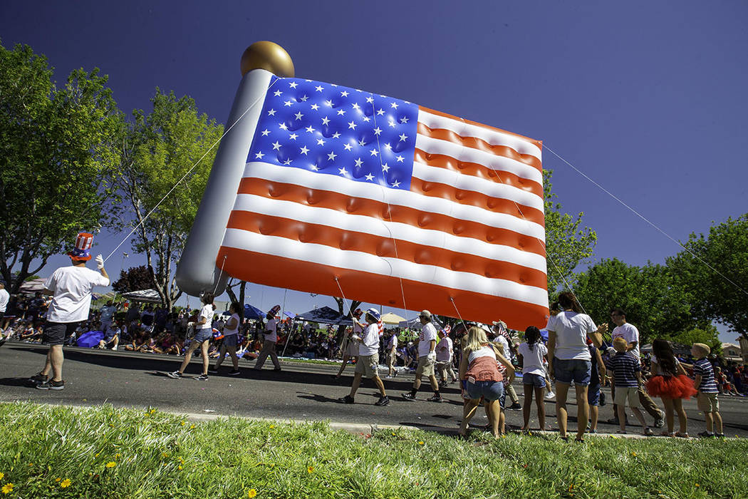 The parade featured traditional floats, giant inflatable balloons, American military heroes, ba ...