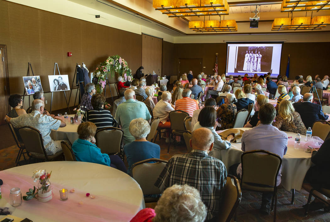 Members and guests watch a slideshow of old wedding images as Gail and Donna Andress have a ren ...