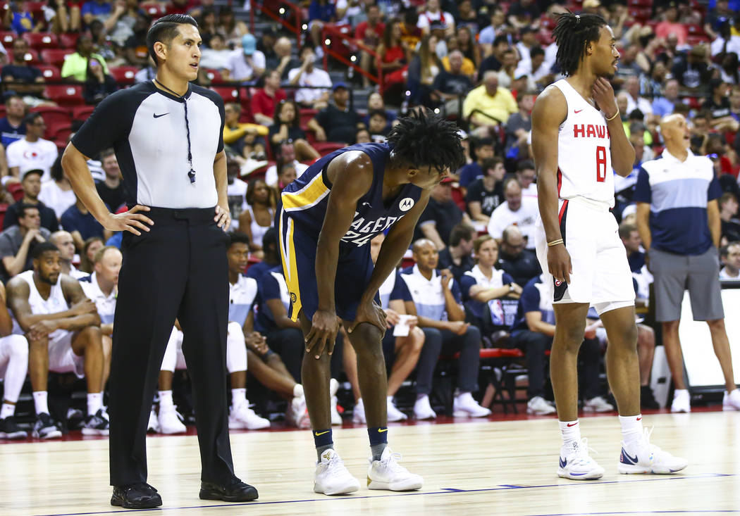 Referee Omar Bermudez, left, stands to watch a free throw attempt while officiating a game betw ...