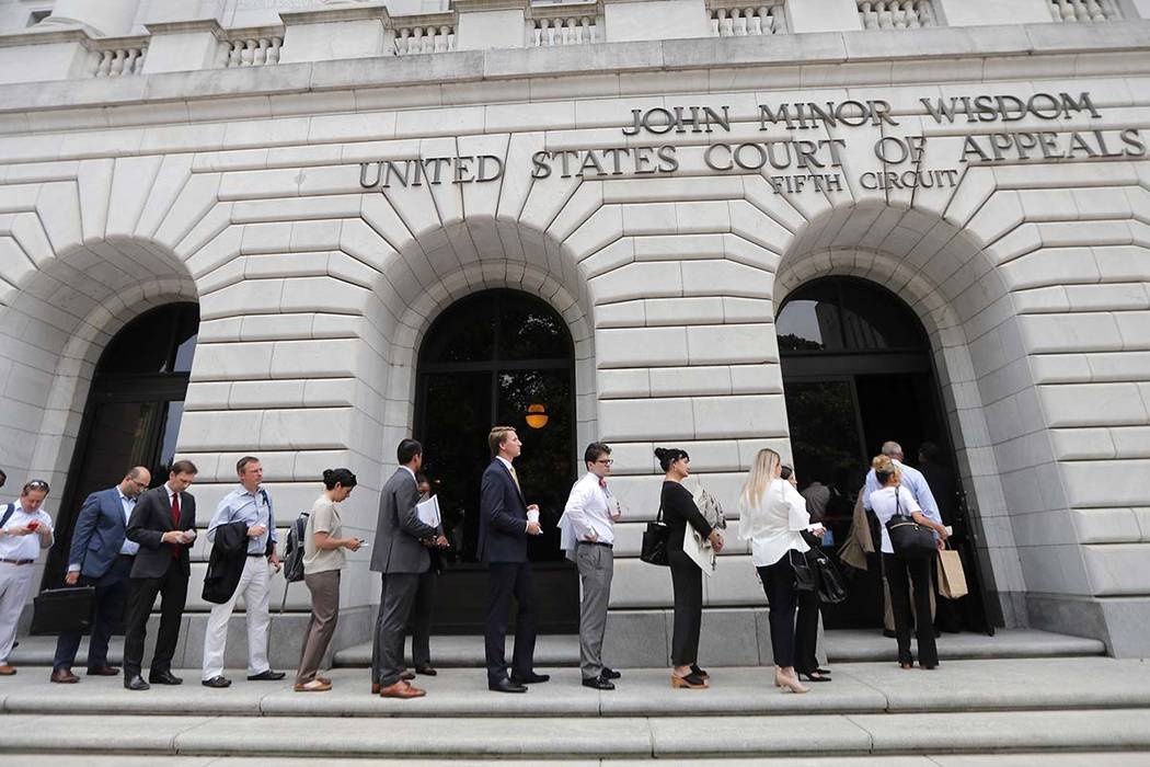 People wait in line to enter the 5th Circuit Court of Appeals to sit in overflow rooms to hear ...