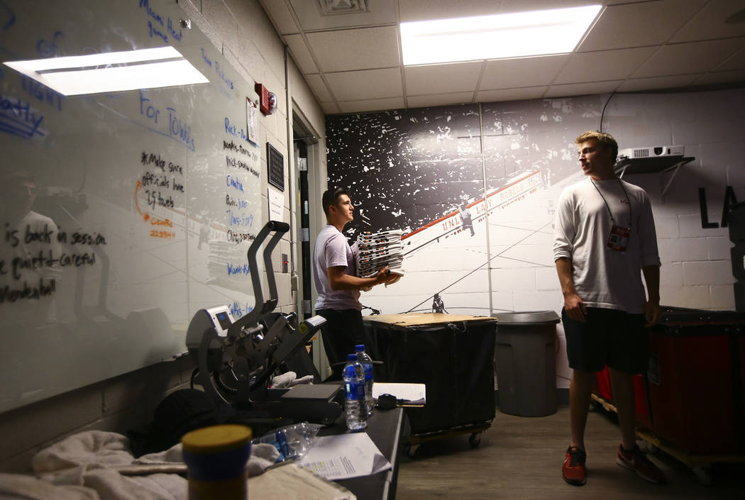 UNLV student Misael Arambula, left, organizes towels next to student assistant equipment manage ...
