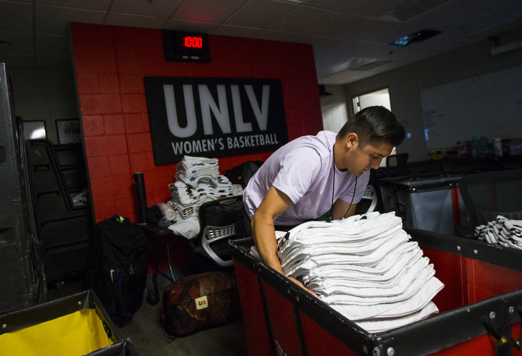 UNLV student Misael Arambula organizes towels as basketball games continue in the Thomas & ...