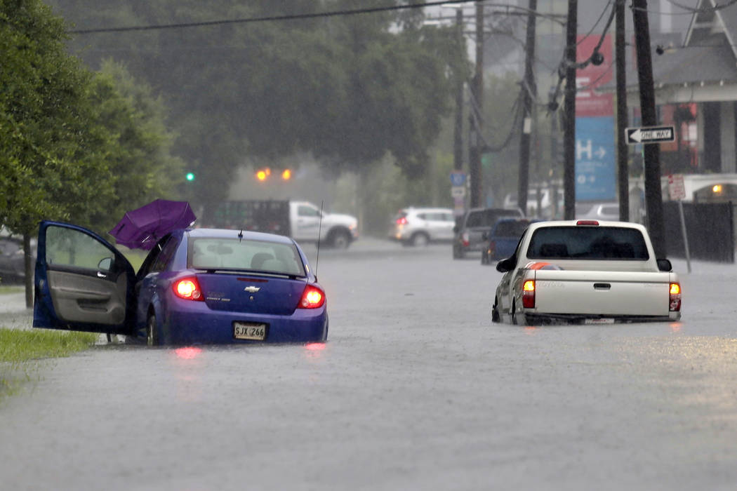 Vehicles are stuck in floodwaters along S. Galvez Street as heavy rain falls, Wednesday, July 1 ...