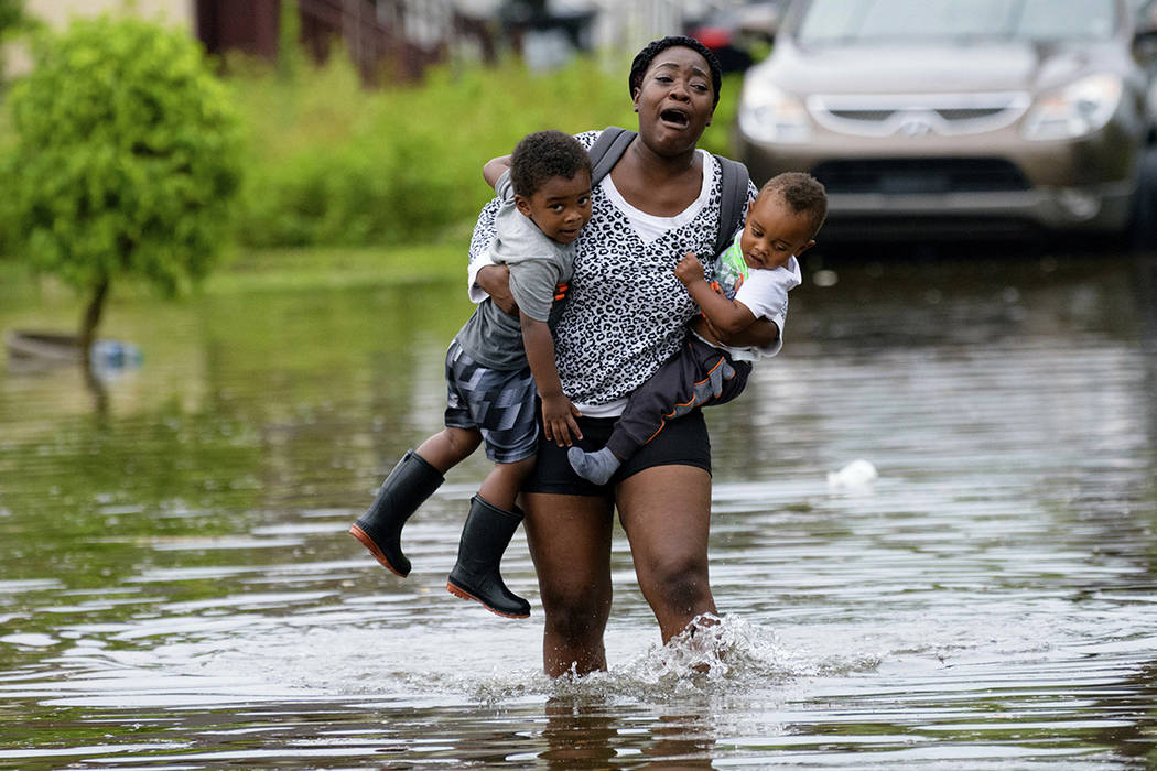 Terrian Jones reacts as she feels something moving in the water at her feet as she carries Drew ...