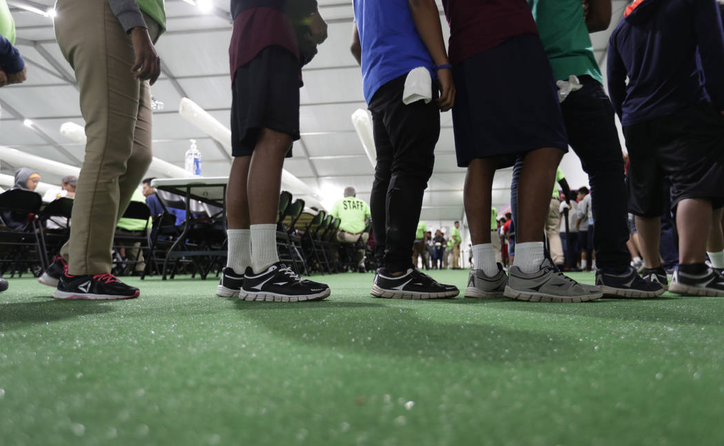 In this July 9, 2019 photo, immigrants line up in the dinning hall at the U.S. government's new ...