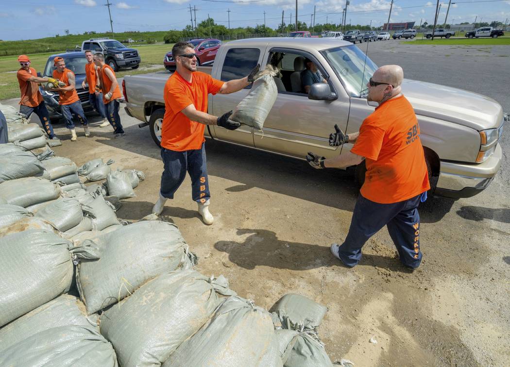St. Bernard Parish Sheriff's Office inmate workers move free sandbags for residents in Chalmett ...
