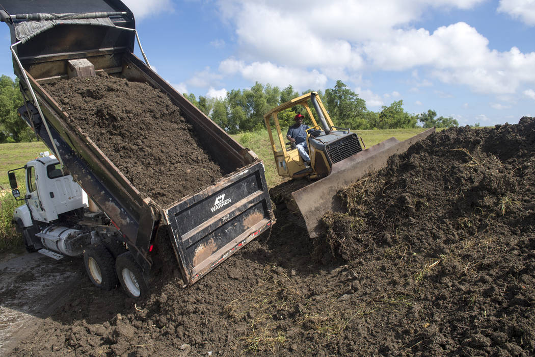 Plaquemines Parish road crews add more dirt to the top of a levee near the Mississippi River le ...