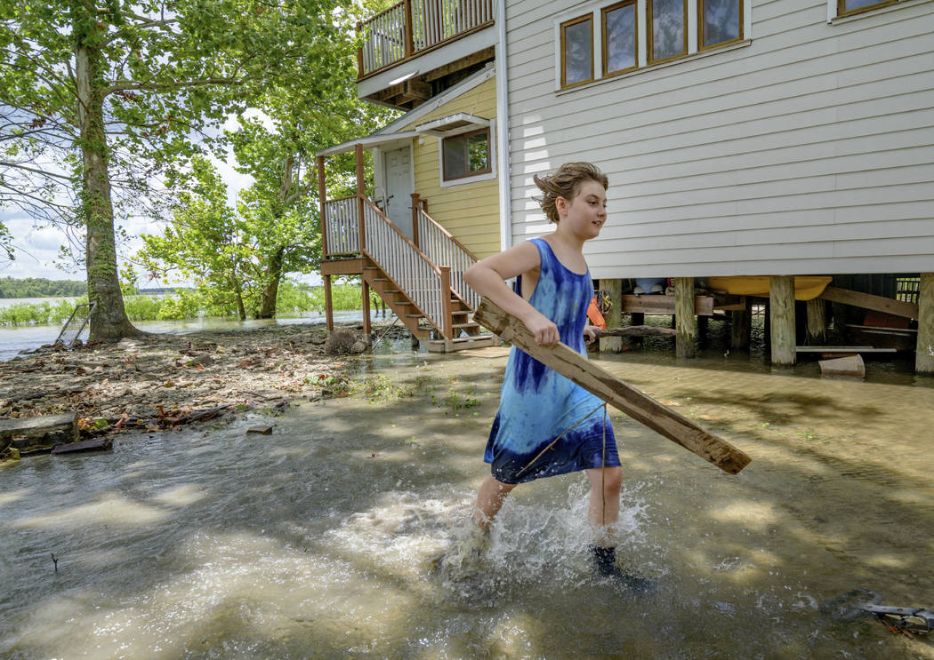 Tallulah Campbell, 8, clears out driftwood and other debris in preparation of Tropical Storm Ba ...