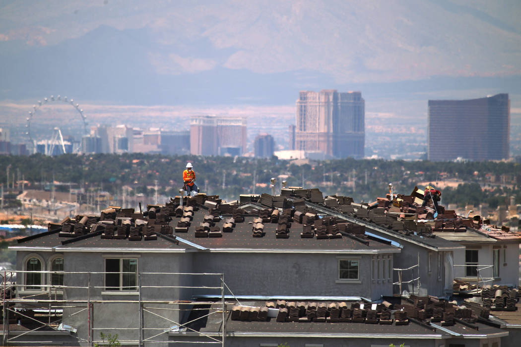 Workers are seen on the roof of an under-construction house in the Cadence master-planned commu ...