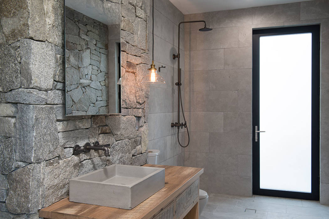 The master bath features lots of natural stone and wood. (Jewel Homes)