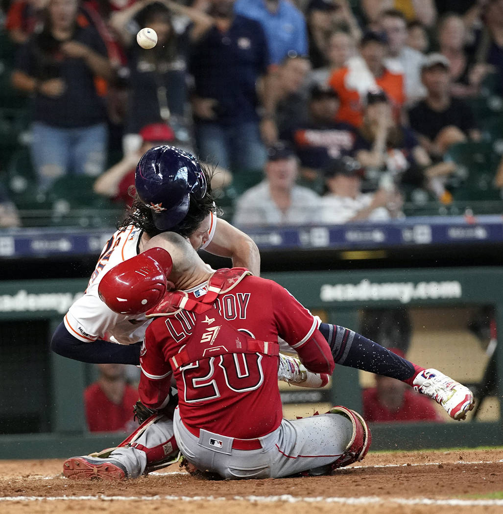 Houston Astros' Jake Marisnick, right, collides Los Angeles Angels catcher Jonathan Lucroy (20) ...