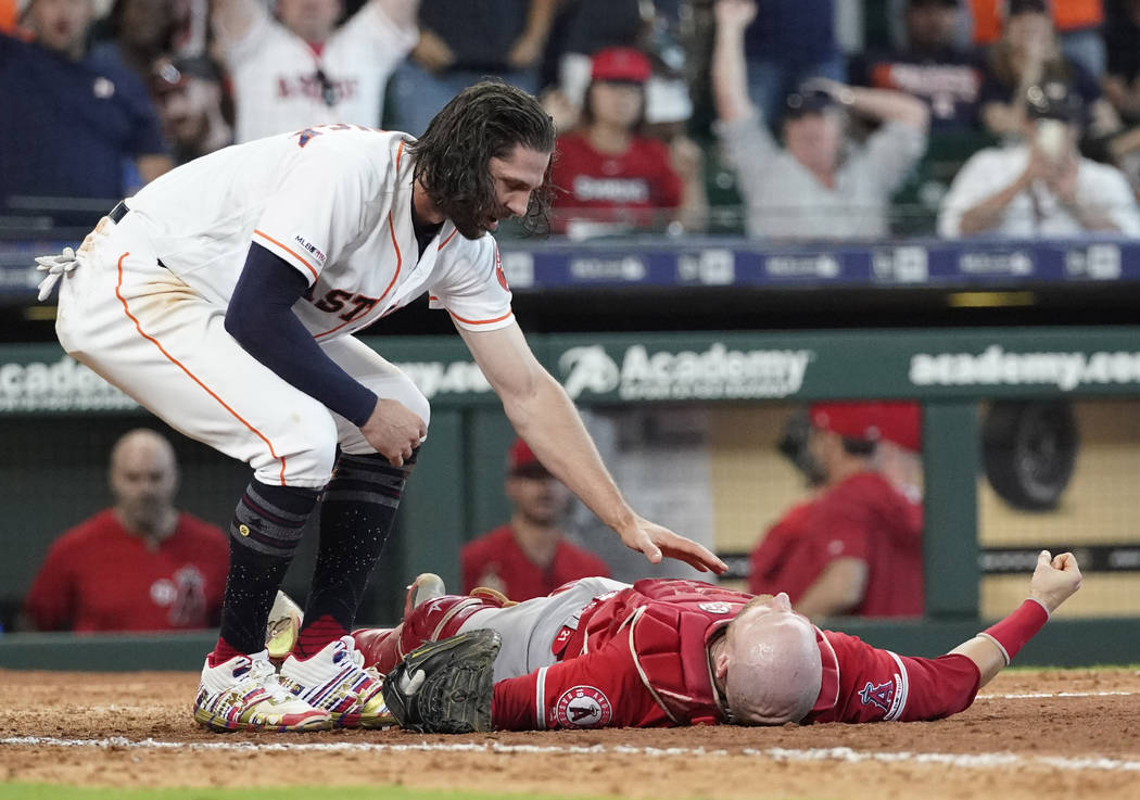 Houston Astros' Jake Marisnick, left, checks on Los Angeles Angels catcher Jonathan Lucroy afte ...