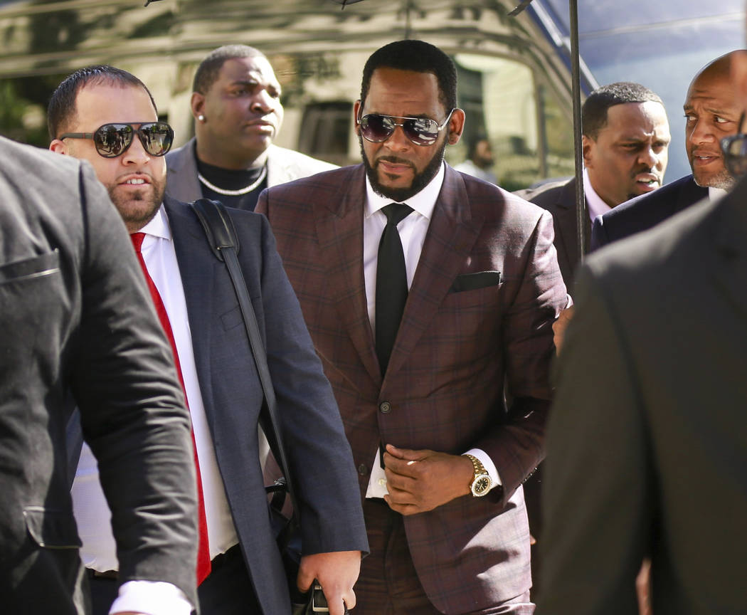 FILE - In this June 26, 2019, file photo, R&B singer R. Kelly, center, arrives at the Leigh ...