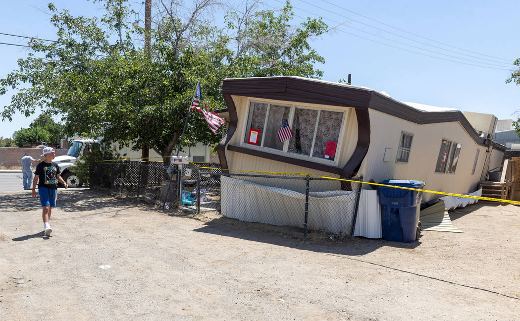 FILE - In this July 5, 2019 file photo, a child walks by one of the mobile homes knocked off it ...