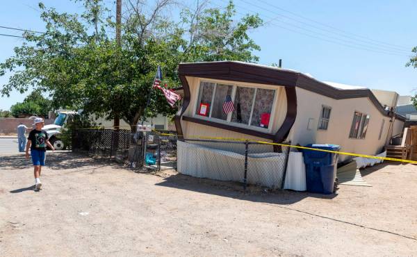 FILE - In this July 5, 2019 file photo, a child walks by one of the mobile homes knocked off it ...