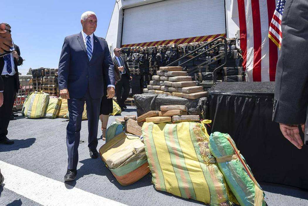 Vice President Mike Pence walks past bales of seized cocaine during a visit to the U.S. Coast G ...