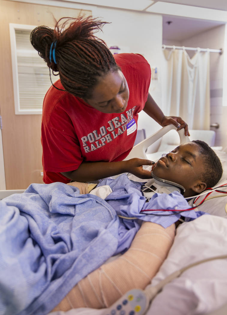 Thylicia McKnight, above, attempts to wake her son Lennie Modica, 9, who is in recovery in the ...