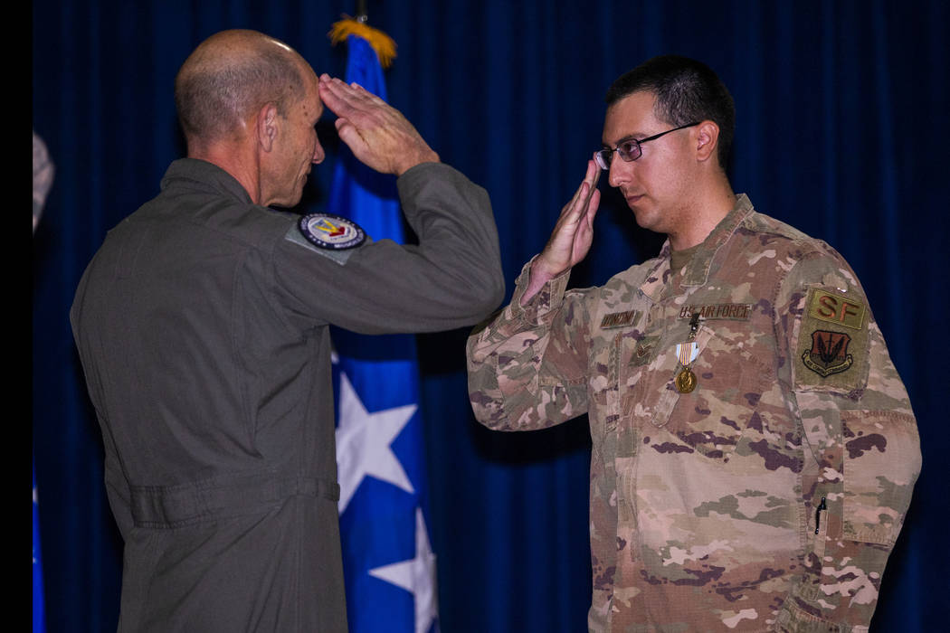 Gen. Mike Holmes, Commander of Air Combat Command, left, salutes with Staff Sgt. Kenneth DeLong ...