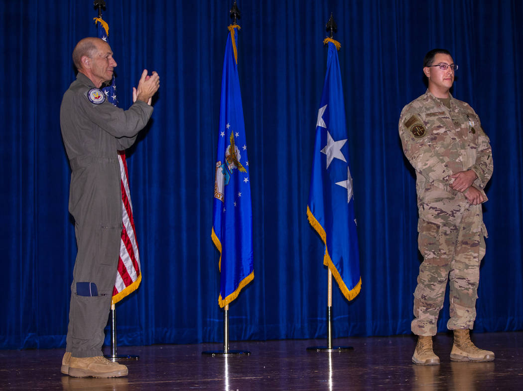 Gen. Mike Holmes, Commander of Air Combat Command, left, claps for Staff Sgt. Kenneth DeLongcha ...