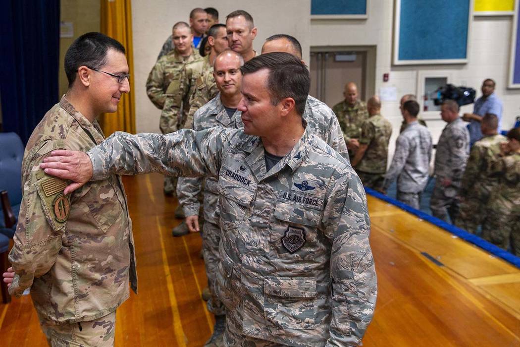 Staff Sgt. Kenneth DeLongchamp, left, is congratulated by other airmen at Nellis Air Force Base ...