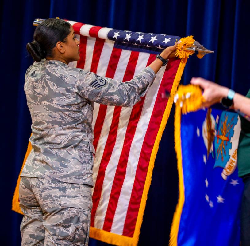 Staff Sgt. Britneyrose Ward rolls up the American flag at Nellis Air Force Base on Friday, July ...