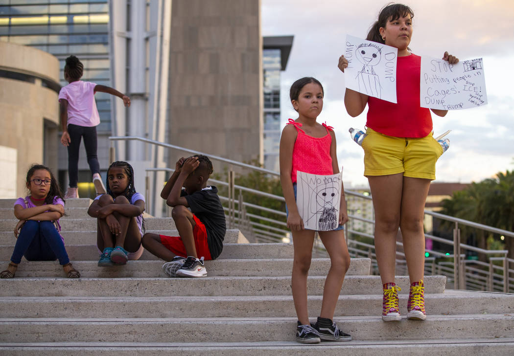 Diana Tarin, 8, left, and her sister Cecilia, 11, stand with handmade signs during Lights for L ...