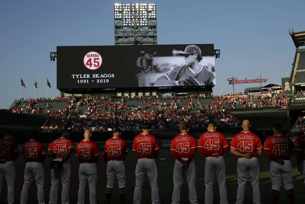 Members of the Los Angeles Angels observe a moment of silence for teammate Tyler Skaggs, before ...