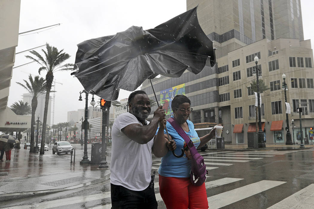 Karon Hill, left, and Celeste Cruz battle the wind and rain from Hurricane Barry as it nears la ...