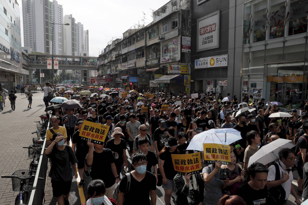 Protesters hold up words that read: "Strict enforcing of law against smugglers of grey goo ...