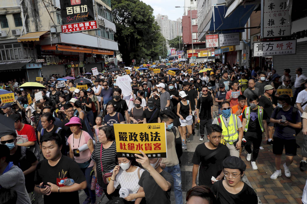 Protesters hold up words that read: "Strict enforcing of law against smugglers of grey goo ...