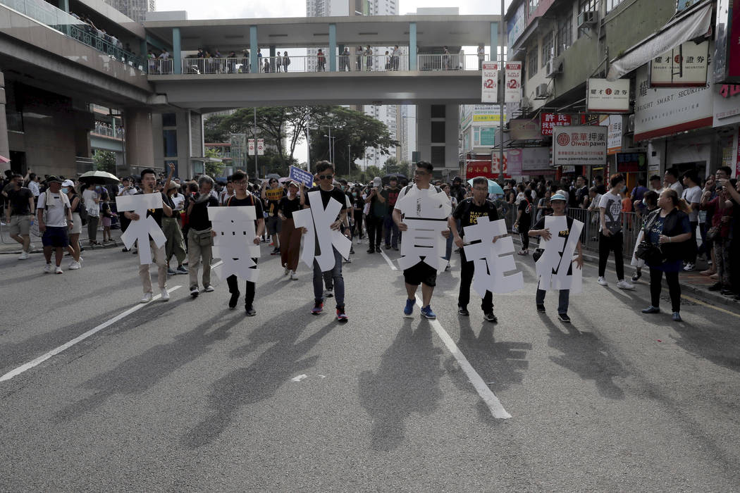 Protesters hold up words that read: "Against smuggling grey goods" in Hong Kong Satur ...