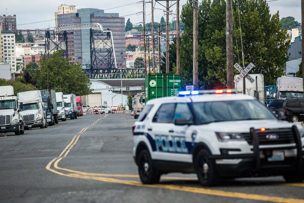 A police officer guards the front of a road block near the Northwest Detention Center, Saturday ...