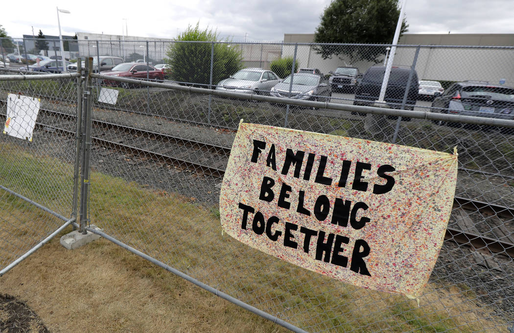 FILE - This July 10, 2018 file photo shows a sign that reads "Families Belong Together" on a fe ...