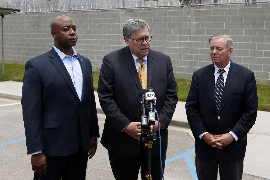 Attorney General William Barr, center, stands with Sen. Tim Scott, R-S.C., left, and Sen. Linds ...