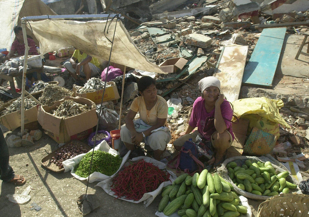 street vendors wait at a market destroyed in a powerful earthquake at Gunung Sitoli, Nias islan ...