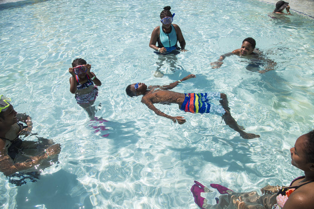 Dillon Hanger, 12, floats in a pool surrounded by his family Tamia Boston, 17, from left, Makay ...